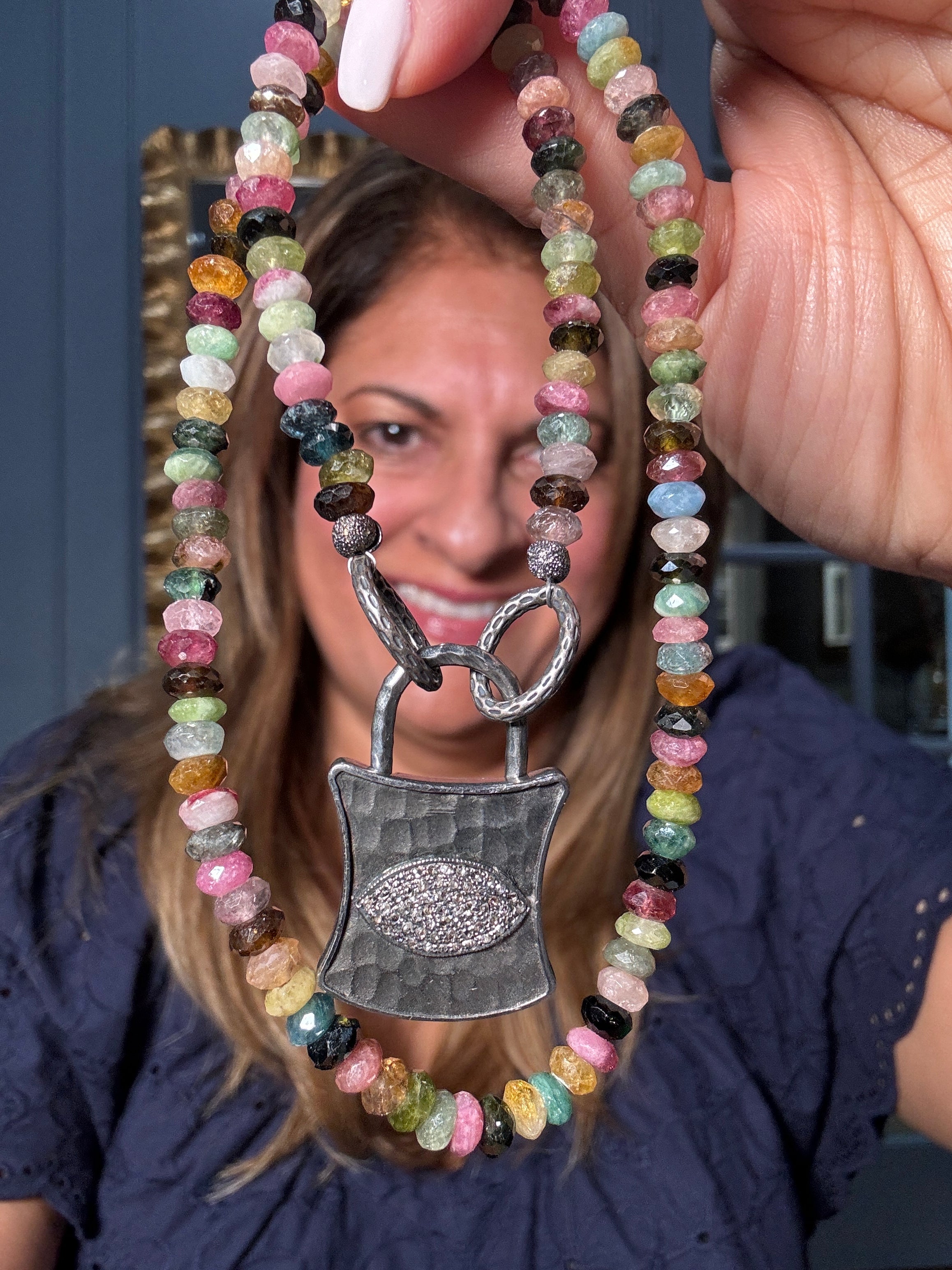 Multicolor tourmaline necklace paired with a sterling silver lock pendant featuring a pavé diamond eye — a symbolic and colorful Ulka Rocks design for stylish self-expression.