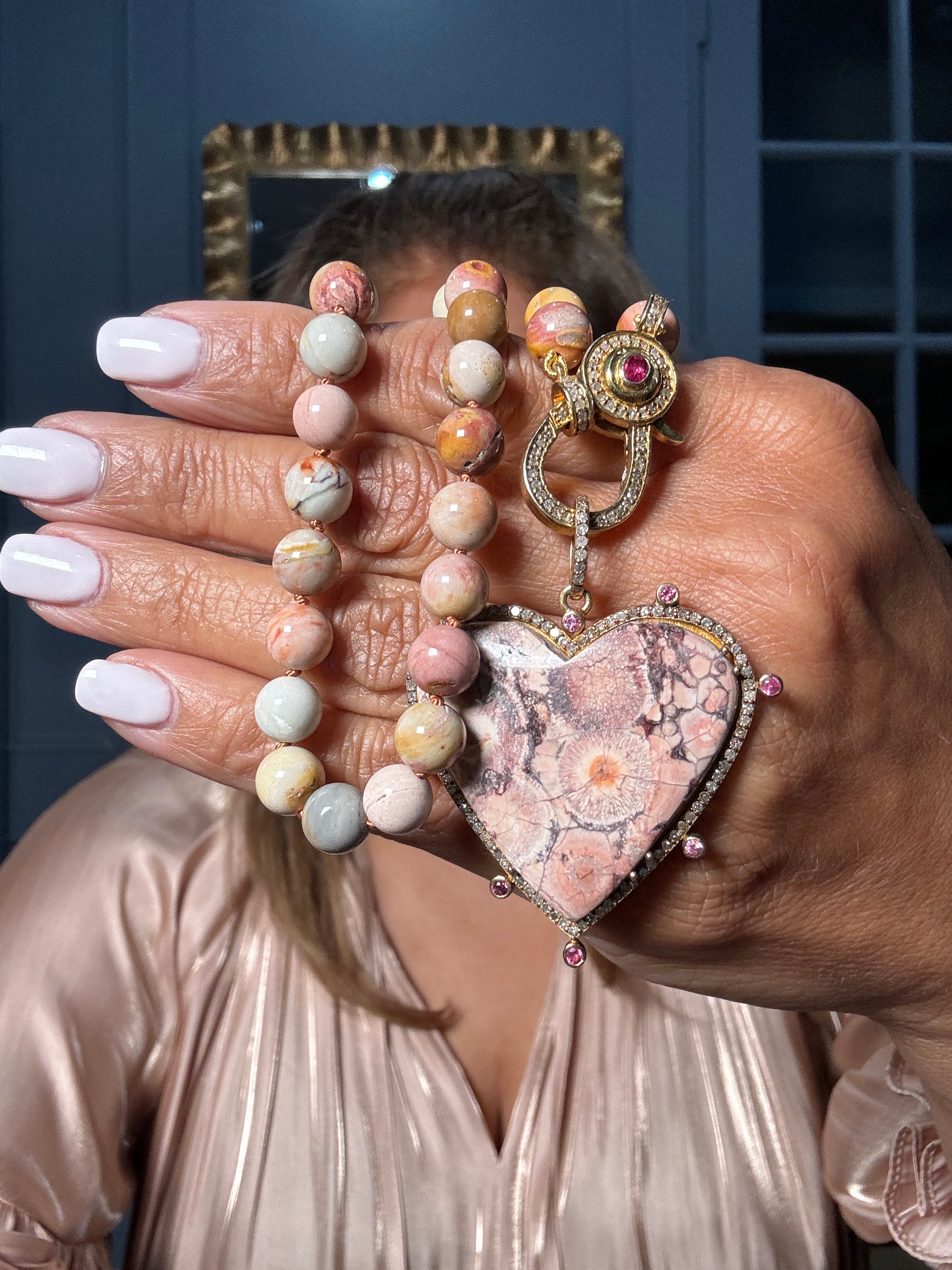 18” jasper necklace with round blush and peach-toned beads, paired with a heart-shaped Bird’s Eye Rhyolite Jasper pendant framed in diamonds and pink sapphires. A one-of-a-kind Ulka Rocks creation.