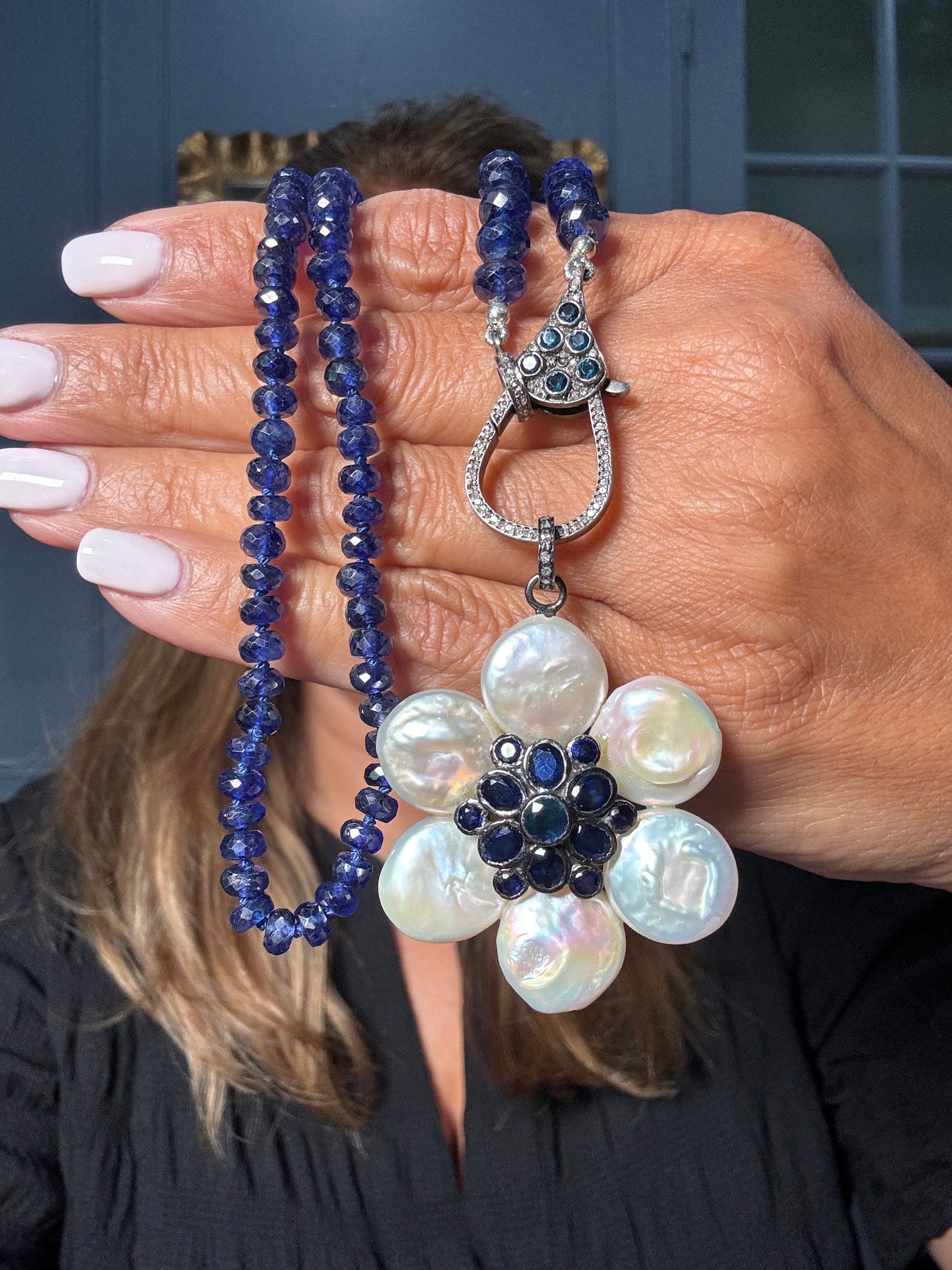 Faceted blue sapphire necklace with freshwater pearl flower pendant and diamond clasp, designed in sterling silver. A one-of-a-kind Ulka Rocks piece with bold, refined appeal.