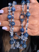 Elegant 36-inch necklace with blue kyanite spheres, clear Herkimer diamonds, and sapphires held delicately in hands with purple manicure, featuring decorative sterling silver clasp.