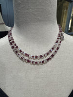 Double-strand 34-inch necklace with rhodolite garnet and moonstone beads displayed on beige mannequin, featuring sterling silver toggle clasp and graceful layered look.