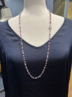 Long rhodolite garnet and moonstone beaded necklace displayed on a gray fabric mannequin against a dark navy shirt, showing elegant draping at 34 inches.
