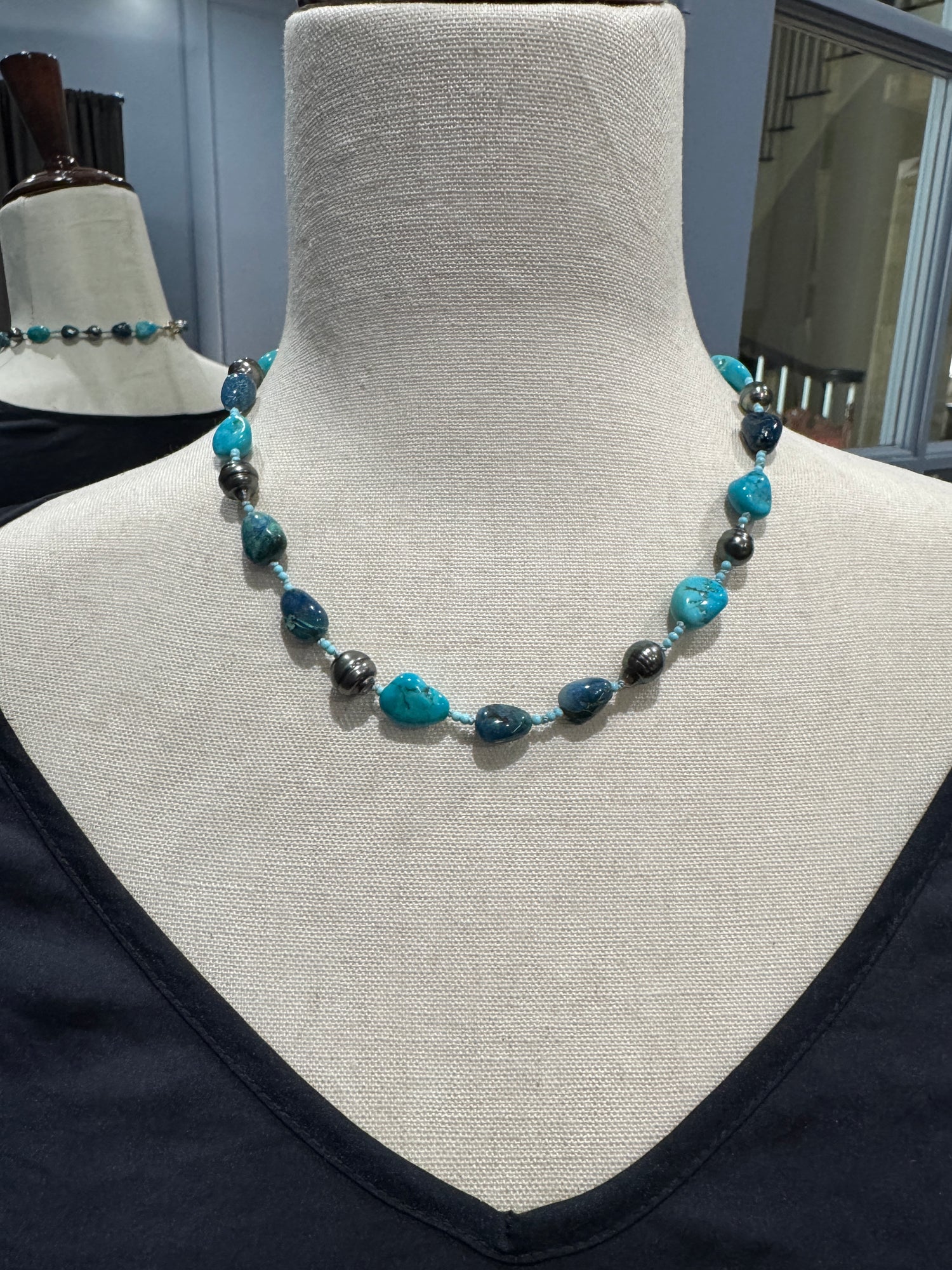 Tahitian pearl and Sleeping Beauty turquoise necklace on mannequin showing 18-inch choker length with alternating blue gemstones and lustrous gray-green pearls