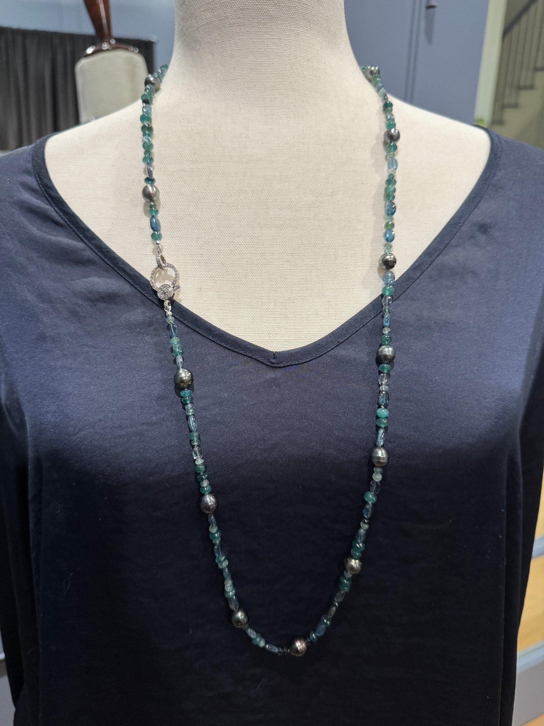 Long 36-inch grandidierite and Tahitian pearl necklace on mannequin showing single-strand drape with teal blue gemstones and dark gray pearls