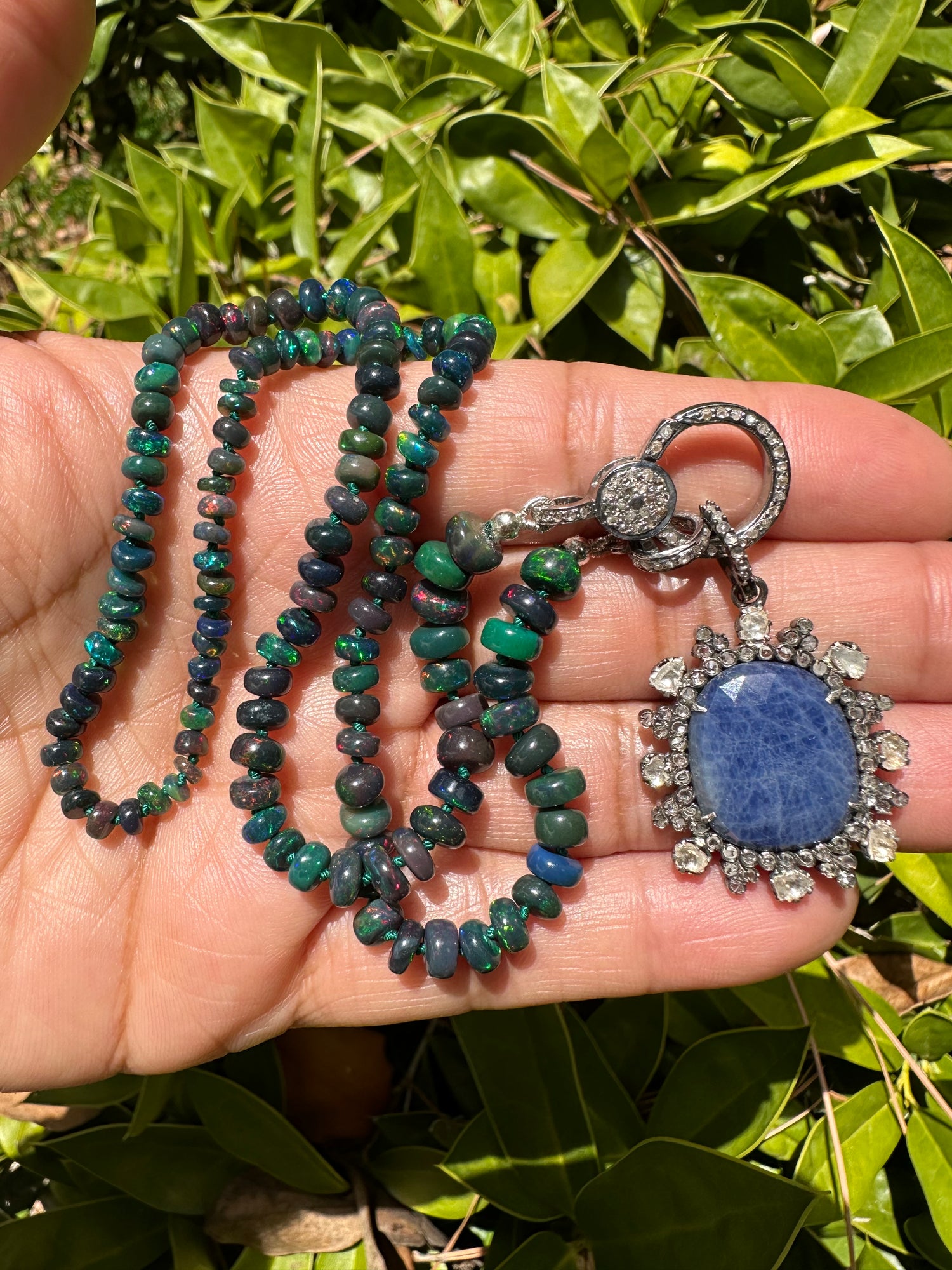 Detail view of Black Opal and Diamond and Emerald necklace pendant combo showing gemstone color and texture