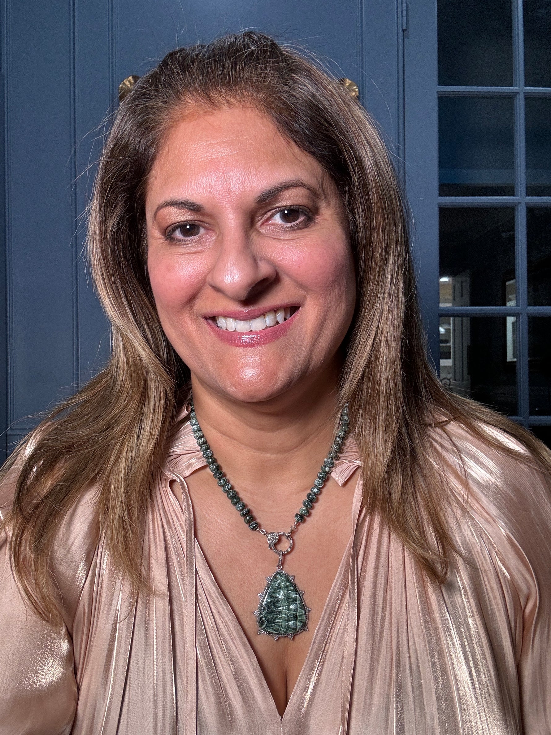 Woman wearing the complete 18-inch azurite-malachite necklace with diamond clasp and teardrop pendant, showcasing the rich blue and green gemstone colors against a champagne blouse.