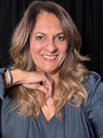 Woman wearing blue topaz crescent pendant necklace, displaying the curved crescent shape with blue gemstones against a gray top