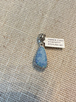 Teardrop-shaped blue Australian opal pendant in simple sterling silver bezel setting with decorative bail, displayed on neutral fabric
