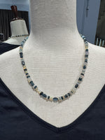 21-inch Ethiopian opal and London blue topaz necklace displayed on cream mannequin, showing alternating iridescent white opal discs and deep blue faceted topaz beads with sterling silver clasp