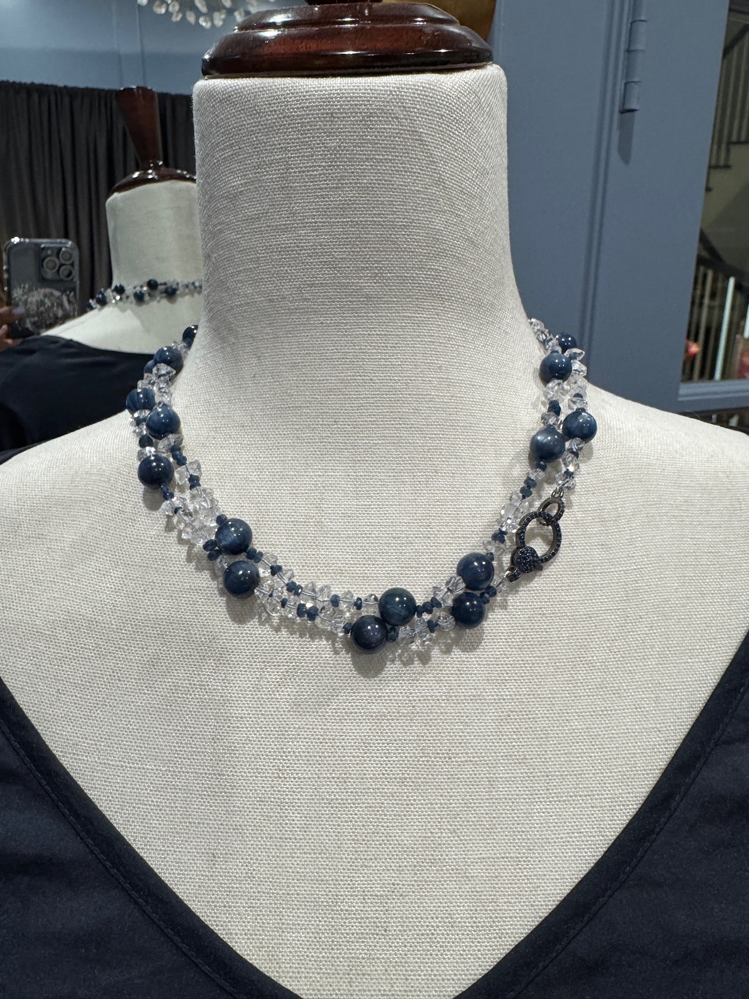 Close-up view of 36-inch beaded necklace with alternating blue kyanite rounds and faceted clear Herkimer diamonds draped around mannequin neck showing luxurious sparkle.