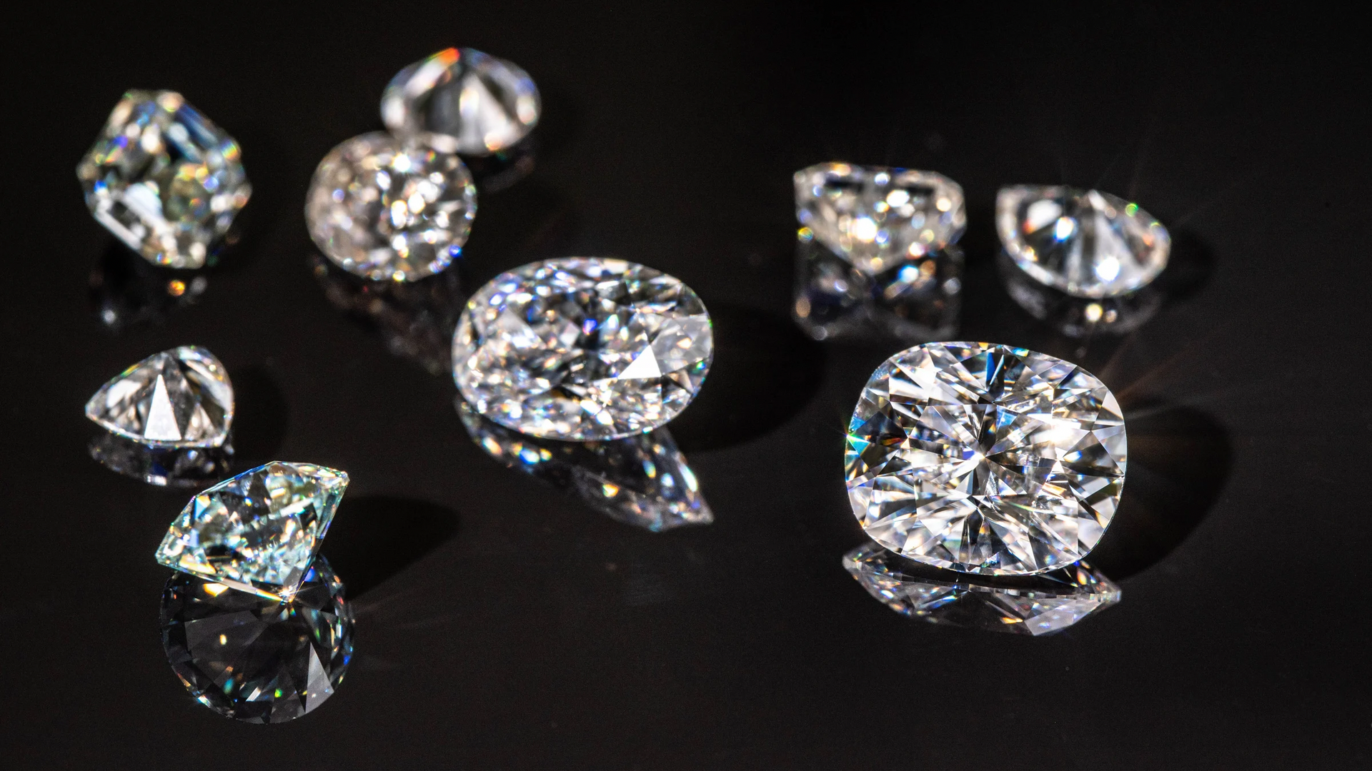 Professional diamond authentication showing expert hands examining natural diamonds, lab-grown stones, moissanite and cubic zirconia with gemological tools and certification documents
