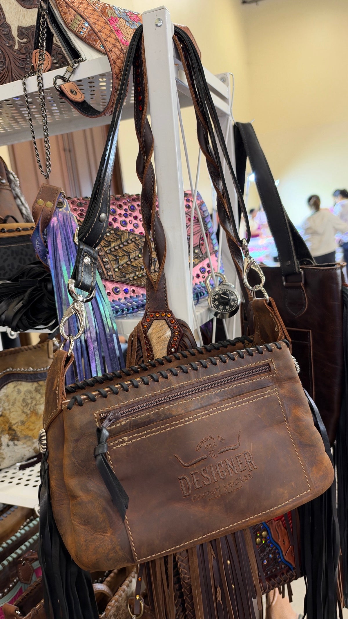 Back of the zebra hide crossbody, distressed brown leather with zip pocket and the Designer Custom Leather stamp