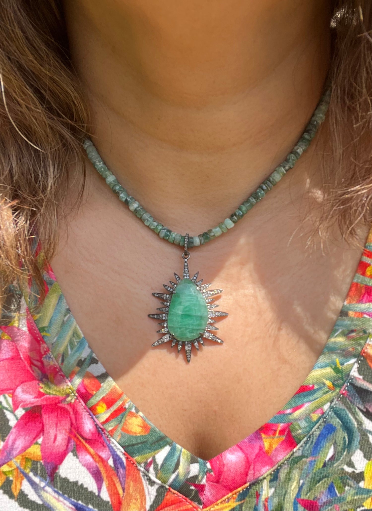 Detail view of Diamond and Emerald necklace showing gemstone color and texture